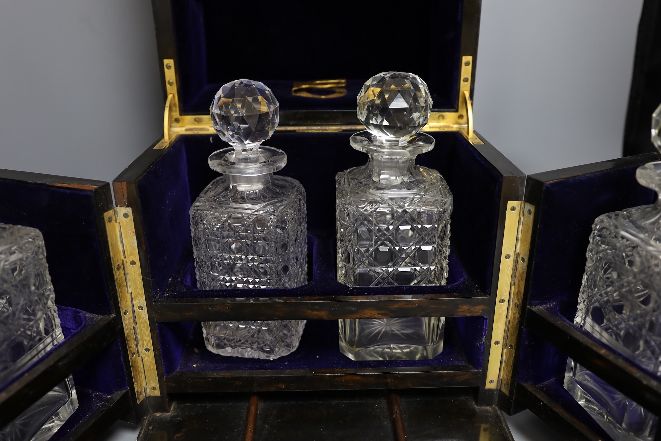 A Mappin & Webb coromandel decanter box with blue velvet lining. 32cm tall, four associated cut glass decanter and stoppers